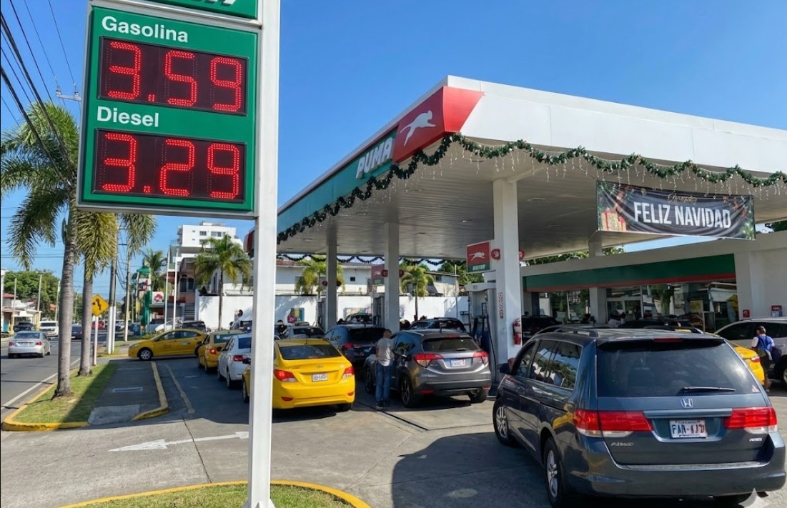 Estación de combustible en Panamá mostrando tableros de precios bajos y flujo vehicular